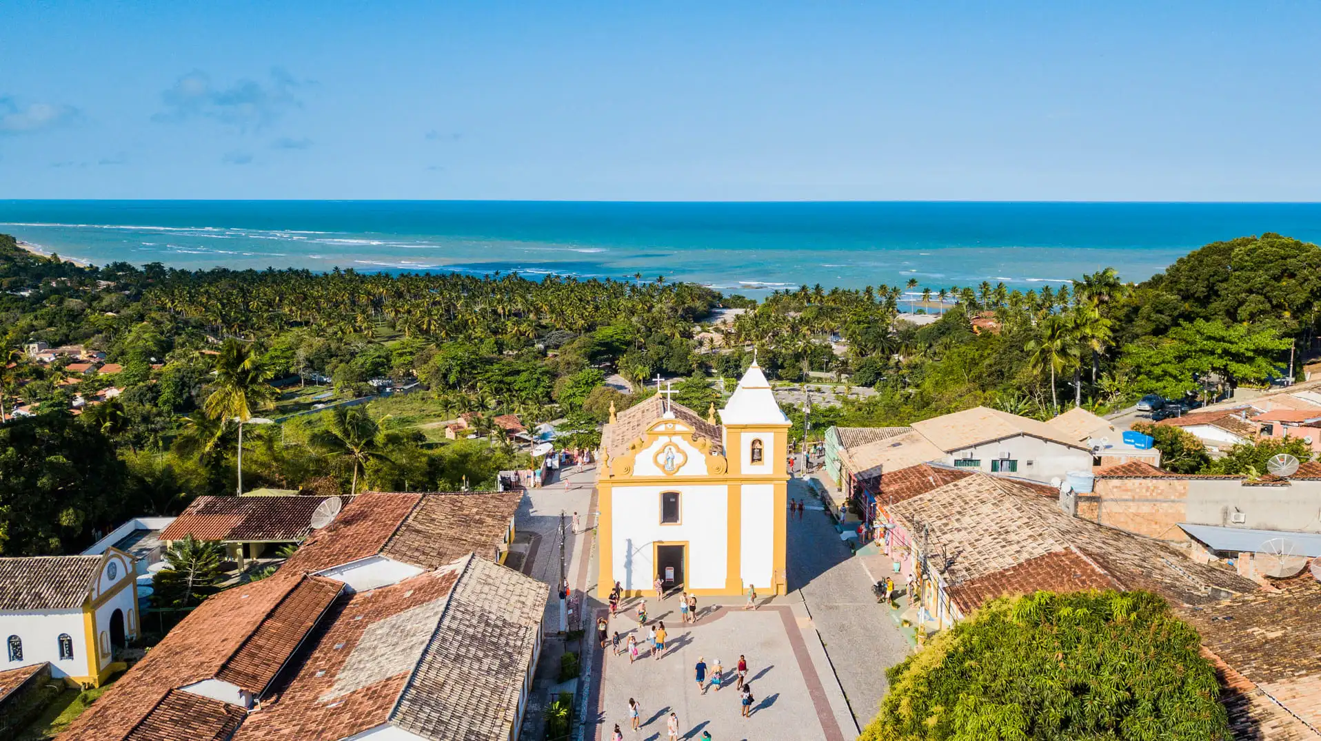 Centro histórico com igreja colonial e mar ao fundo